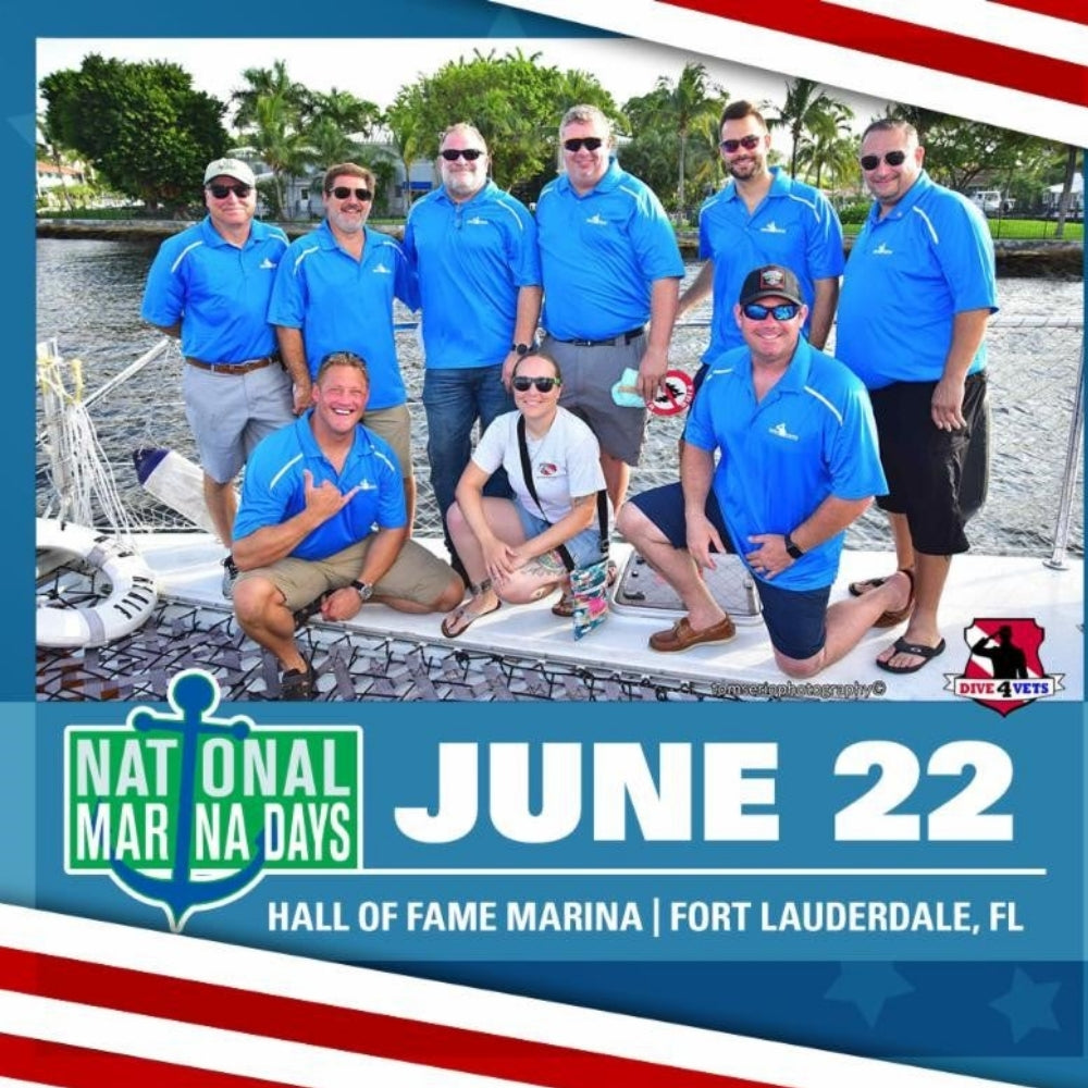 Group of people in blue shirts posing on a boat with National Marina Days promotion.